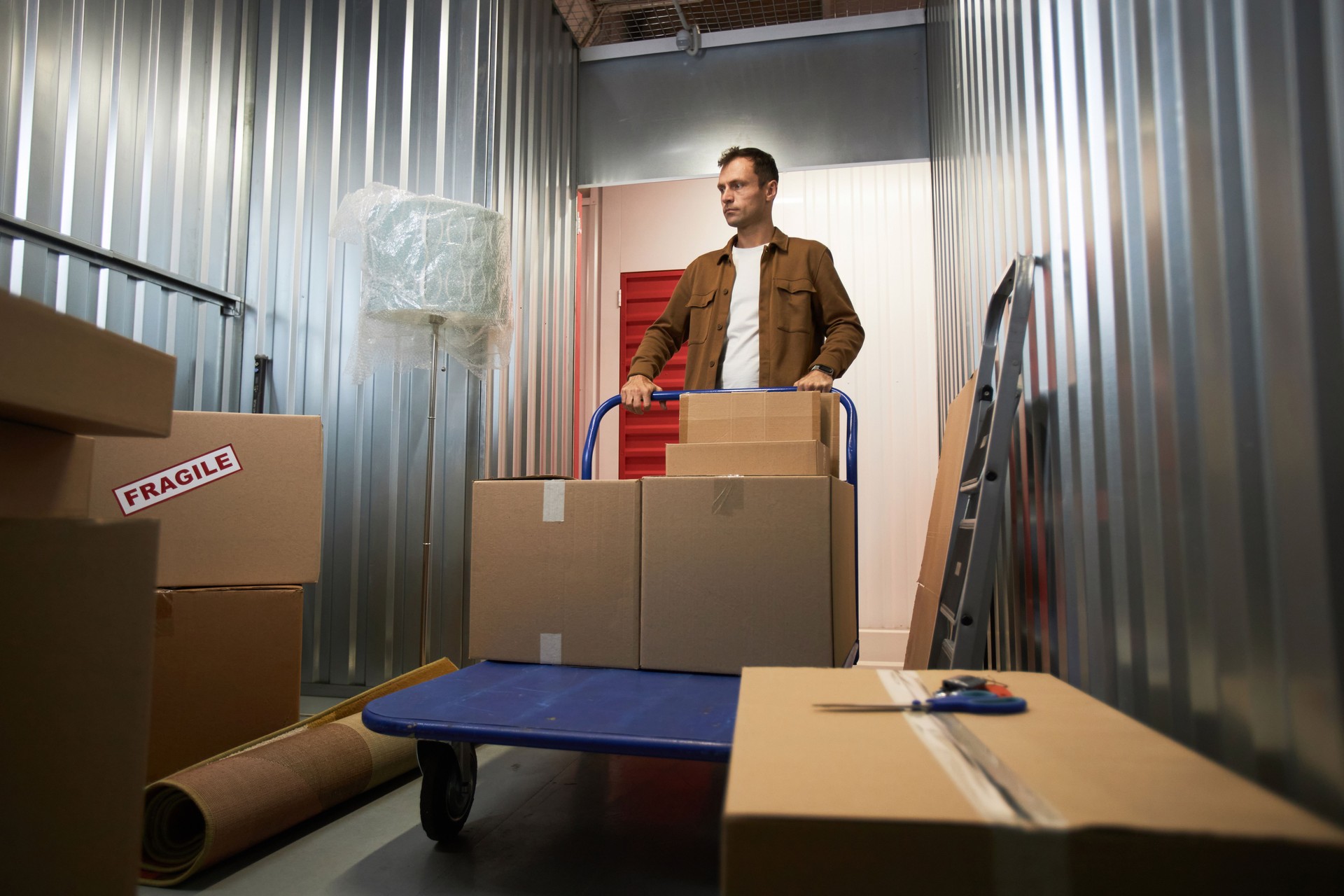 Man Pushing Cart inside Storage Unit