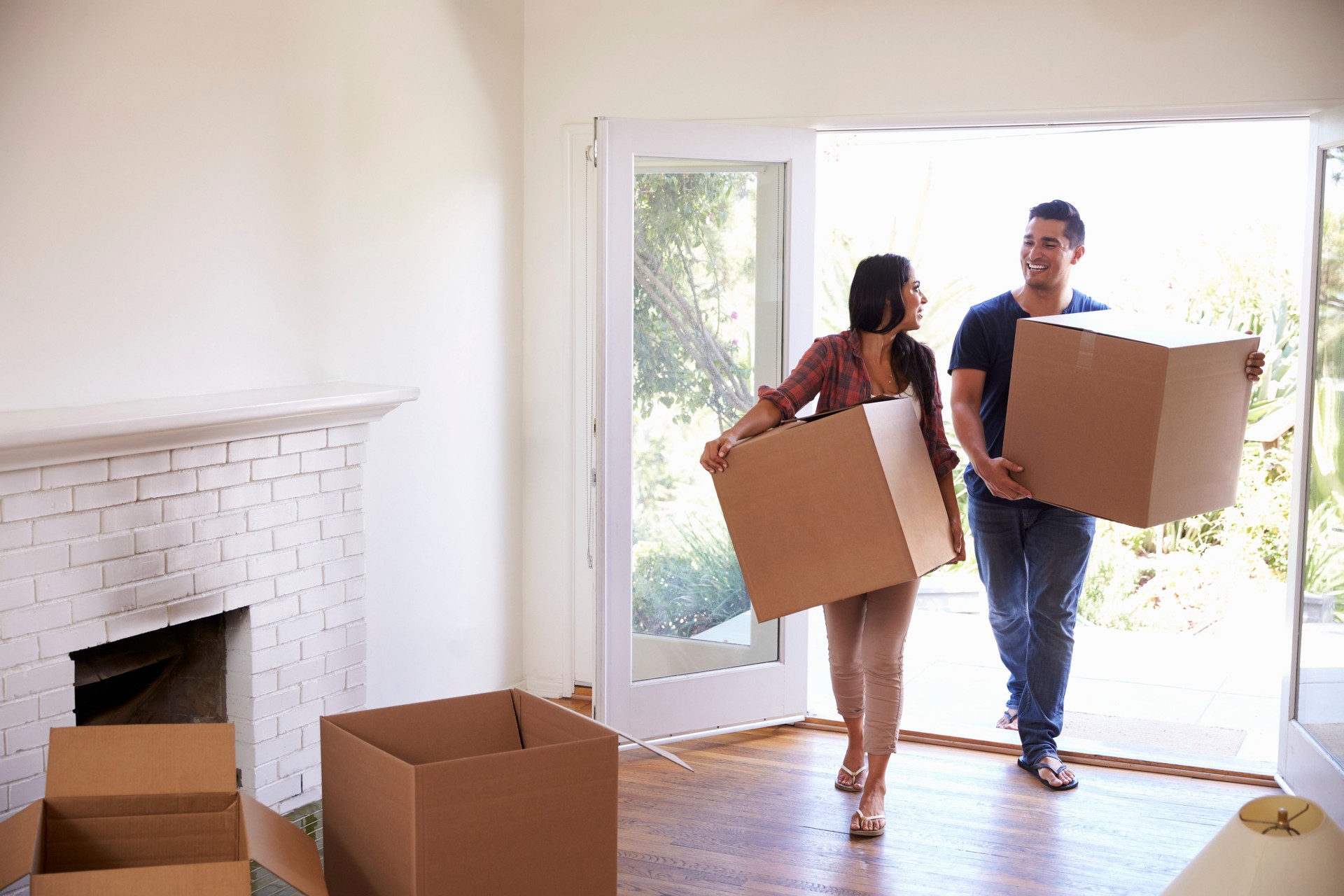 Couple Carrying Boxes Into New Home On Moving Day